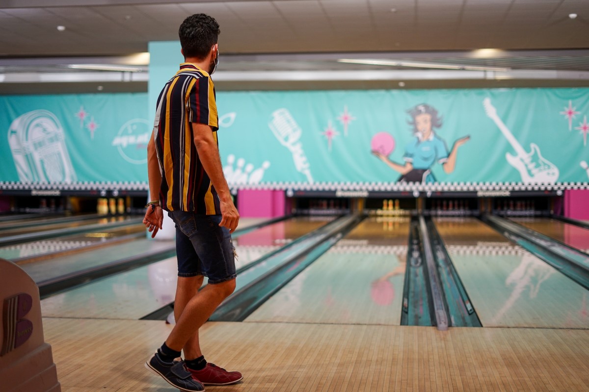 man bowling in bowling alley